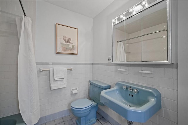 full bathroom featuring a shower with shower curtain, tile patterned flooring, a sink, and toilet