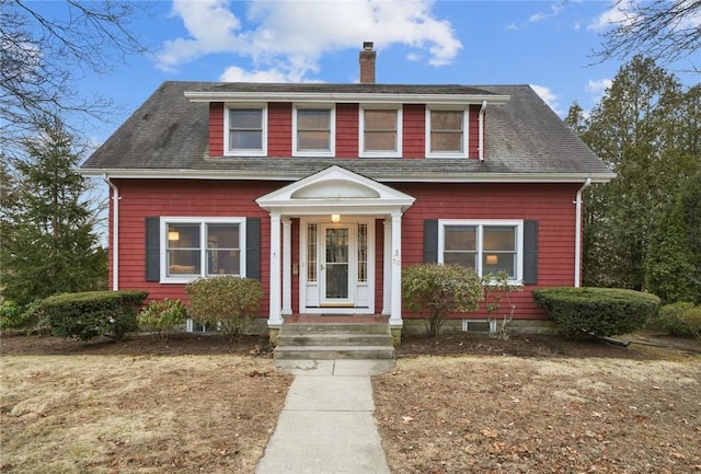 view of front of house featuring a shingled roof and a chimney