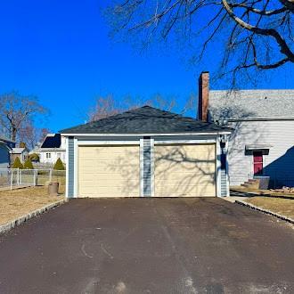 garage with driveway and fence