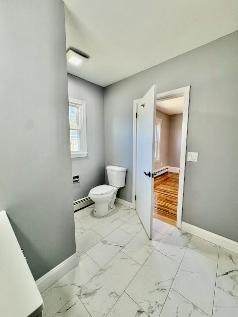 bathroom with a baseboard radiator, marble finish floor, and baseboards