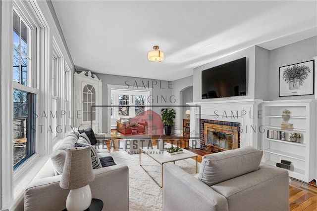 living room with a fireplace with flush hearth and wood finished floors