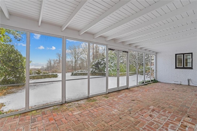 unfurnished sunroom with a wealth of natural light and beamed ceiling