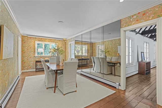 dining space featuring ornamental molding, baseboard heating, hardwood / wood-style flooring, and wallpapered walls