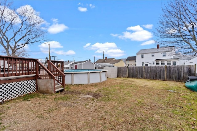 view of yard with a fenced in pool, fence, and a deck