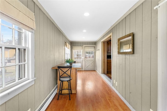 doorway with recessed lighting, a baseboard radiator, light wood-style flooring, and a healthy amount of sunlight