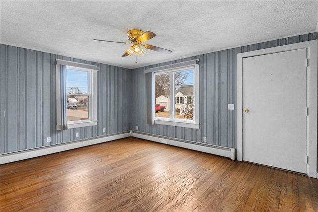 unfurnished room with ceiling fan, a textured ceiling, and hardwood / wood-style floors