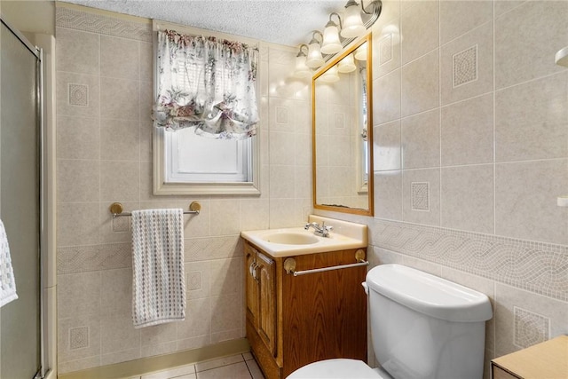 bathroom with tile patterned flooring, tile walls, and a shower with shower door