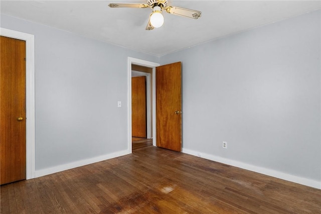 empty room featuring wood finished floors, a ceiling fan, and baseboards