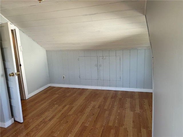 bonus room with lofted ceiling, baseboards, and wood finished floors