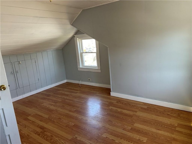 bonus room featuring vaulted ceiling, baseboards, and wood finished floors