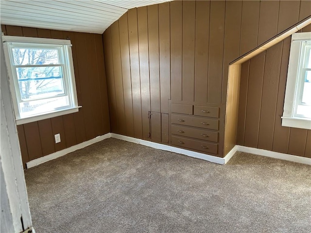 unfurnished bedroom with carpet and wooden walls