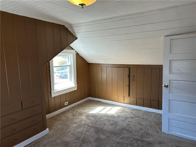 bonus room featuring wooden walls, carpet, lofted ceiling, and baseboards