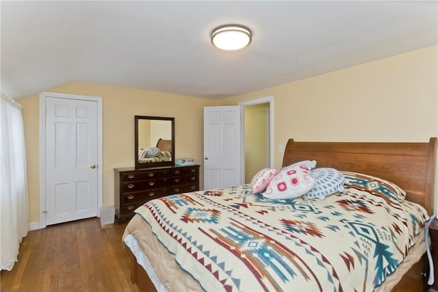 bedroom with lofted ceiling, wood-type flooring, and baseboards