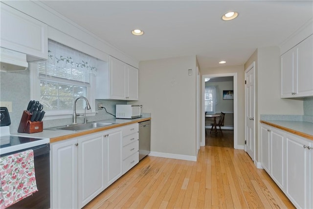 kitchen with white microwave, range with electric stovetop, a sink, white cabinetry, and stainless steel dishwasher