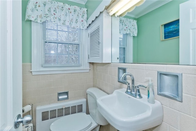 bathroom featuring radiator heating unit, a sink, toilet, and tile walls