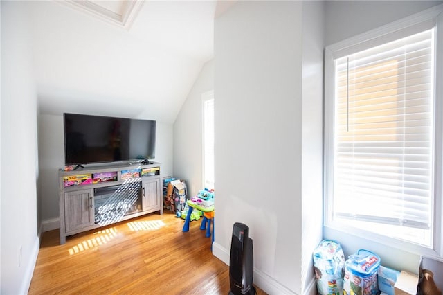 playroom with lofted ceiling, baseboards, and light wood finished floors