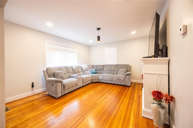 living area featuring recessed lighting, light wood-type flooring, visible vents, and baseboards