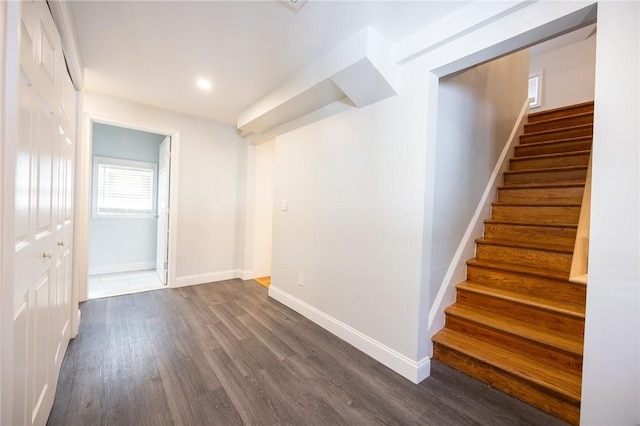 interior space featuring dark wood-style floors, stairs, and baseboards