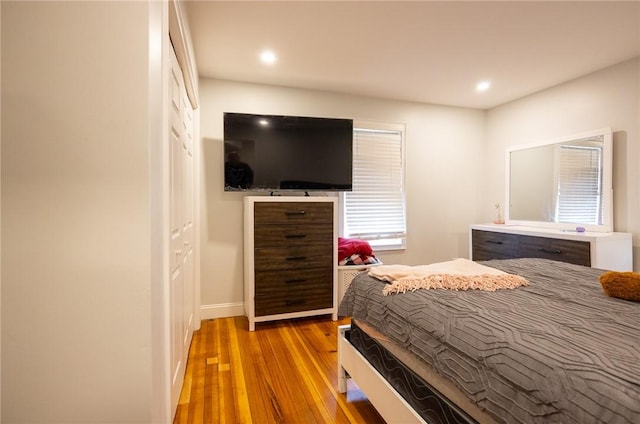 bedroom with recessed lighting and wood finished floors