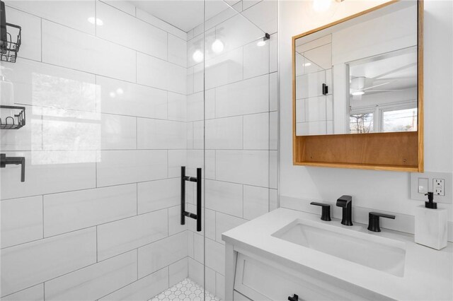 bathroom with a shower stall, vanity, and a ceiling fan