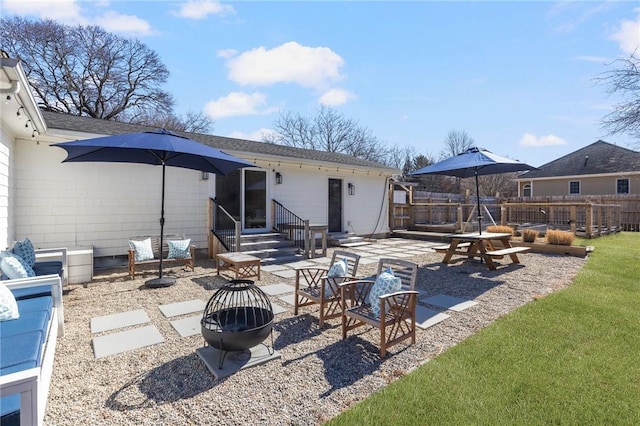 back of property with entry steps, a patio, an outdoor fire pit, and fence