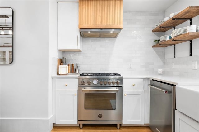 kitchen featuring stainless steel appliances, white cabinetry, light countertops, decorative backsplash, and open shelves