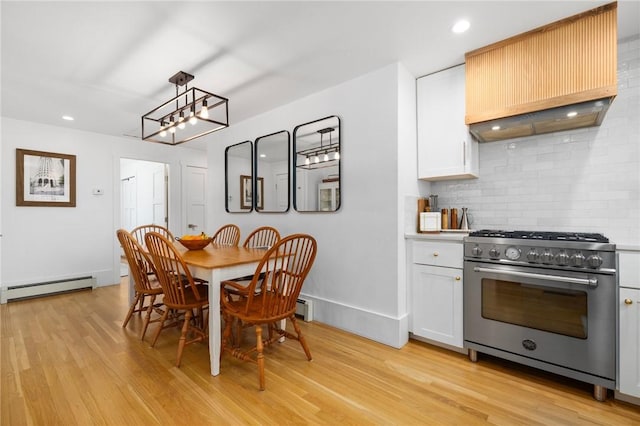 dining space featuring a baseboard heating unit, light wood-type flooring, baseboards, and recessed lighting