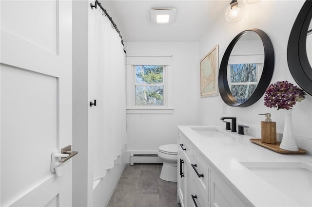 full bathroom featuring a baseboard heating unit, a sink, toilet, and double vanity