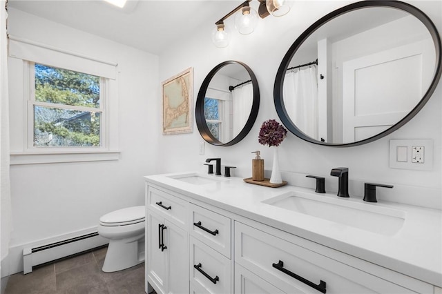 full bathroom with a baseboard heating unit, double vanity, a sink, and toilet