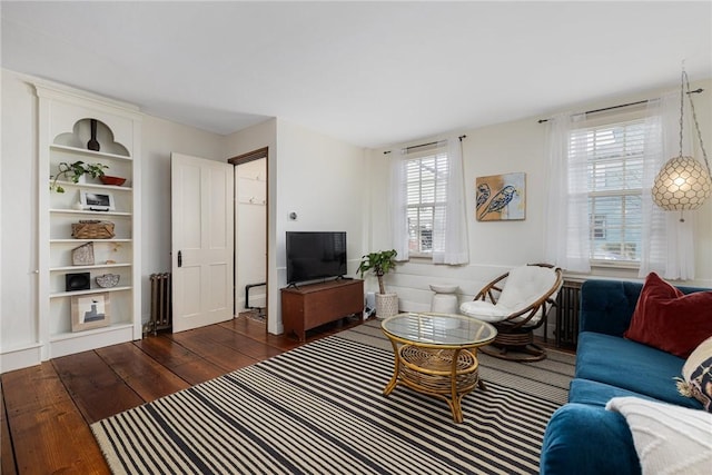 living room with radiator heating unit and dark wood finished floors