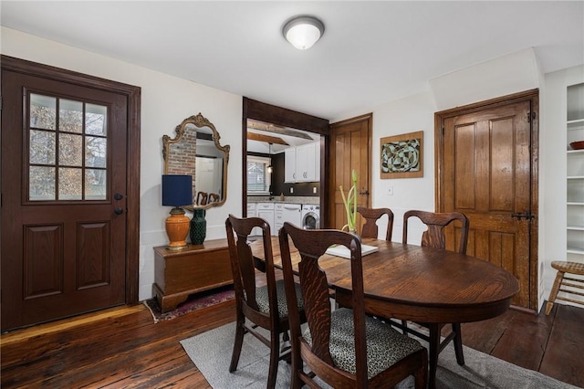 dining room with dark wood-style flooring and washer and dryer