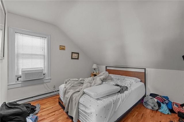 bedroom with a baseboard heating unit, vaulted ceiling, cooling unit, and wood finished floors