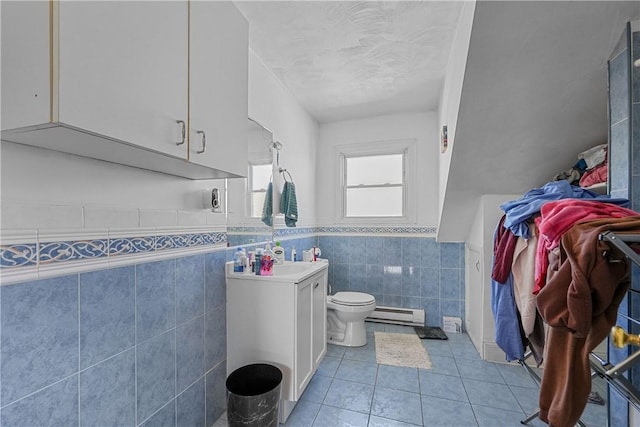 bathroom featuring wainscoting, toilet, a baseboard radiator, tile patterned floors, and vanity