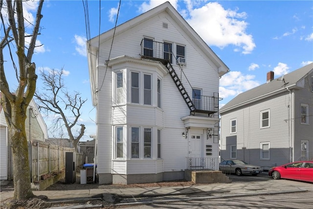 view of front of property with fence and a balcony