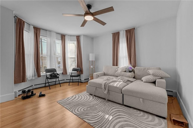 living room with baseboards, a ceiling fan, baseboard heating, and wood finished floors