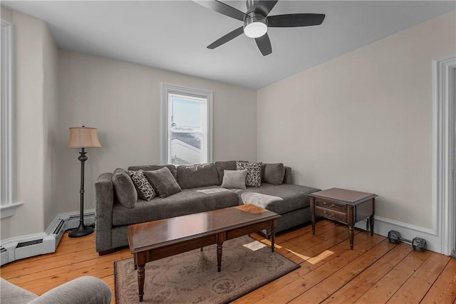 living room with light wood-style floors, baseboard heating, ceiling fan, and baseboards