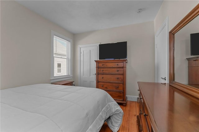 bedroom featuring light wood finished floors and a closet