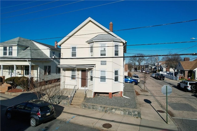 view of front of home with a residential view and a chimney