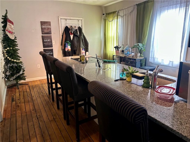 dining area featuring baseboards, dark wood-style flooring, and a healthy amount of sunlight