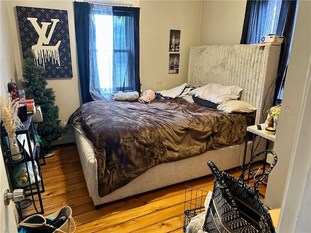 bedroom with wood-type flooring and baseboard heating