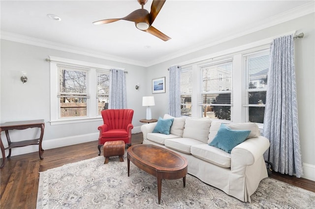 living area with baseboards, ornamental molding, a wealth of natural light, and wood finished floors