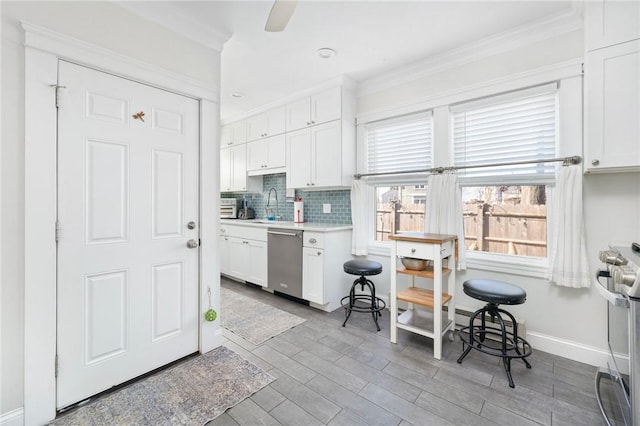 kitchen featuring white cabinetry, tasteful backsplash, appliances with stainless steel finishes, and crown molding