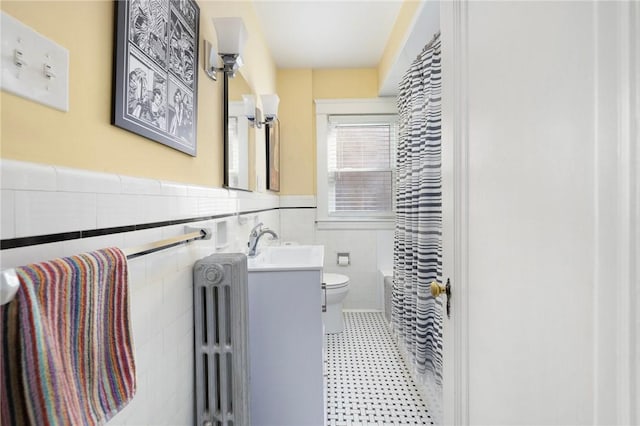 full bath with toilet, vanity, wainscoting, radiator, and shower / bath combo with shower curtain