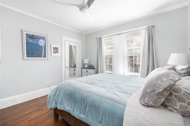 bedroom with a closet, ornamental molding, ceiling fan, wood finished floors, and baseboards