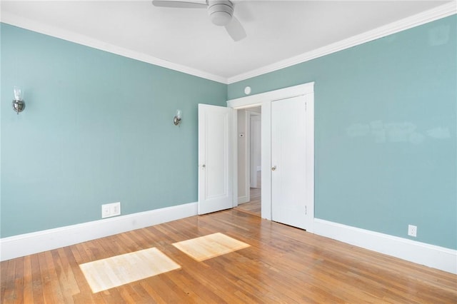 empty room featuring hardwood / wood-style floors, a ceiling fan, baseboards, and crown molding