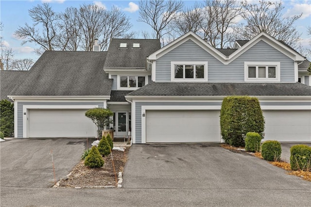 view of front facade with a shingled roof and aphalt driveway