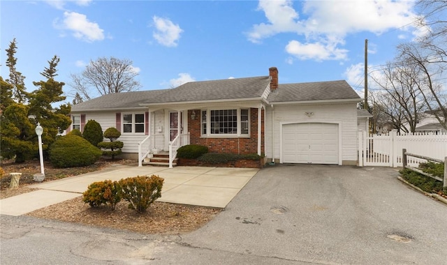 ranch-style home with a chimney, aphalt driveway, an attached garage, fence, and brick siding