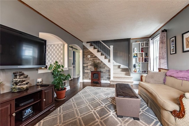 living area with arched walkways, wood finished floors, a textured ceiling, and stairs