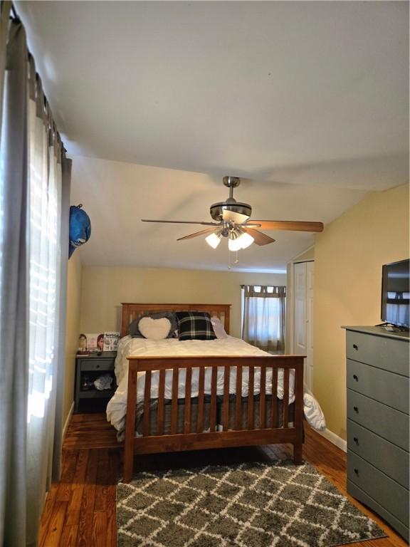 bedroom with wood finished floors, a ceiling fan, and baseboards