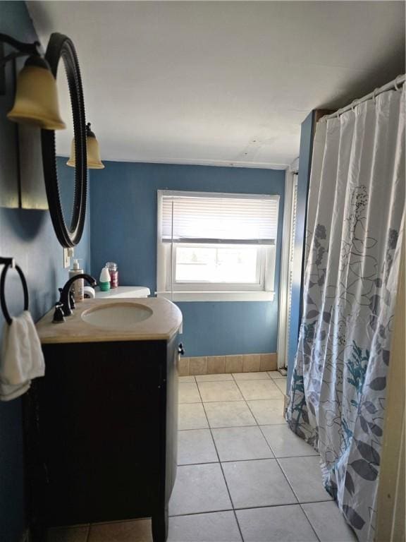 bathroom featuring a shower with shower curtain, vanity, baseboards, and tile patterned floors